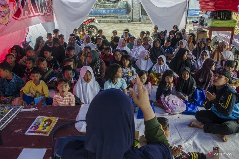 Suasana belajar mengajar yang diselenggarakan oleh valounter di sebuah tenda di lokasi pasca bencana Cianjur. (Foto Antara)