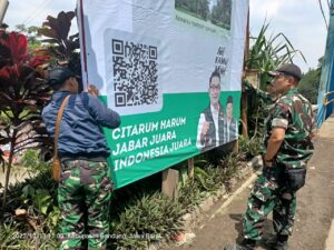 Anggota Satgas Citarum Harum Sektor 6 Sedang Memasangkan Banner Himbauan Kepada Masyarakat Untuk Peduli Terhadap Lingkungan