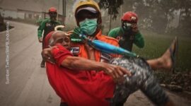 Petugas BPBD Lumajang sedang mengevakuasi salah seorang warga dari erupsi gunung Semeru. Lumajang, Minggu 4/12/22