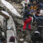Orang-orang dan tim darurat menyelamatkan seseorang dengan tandu dari bangunan yang runtuh di Adana, Turki, Senin, 6 Februari 2023. Gempa berkekuatan magnitudo 7,8 telah menyebabkan kerusakan signifikan di tenggara Turki dan Suriah. (IHA agency via AP)