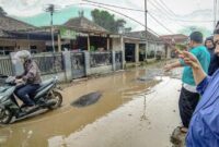 Warga melaksanakan aksi mancing bersama di jalan rusak sebagai aksi protes kepada Pemkab Bandung Barat, Senin (27/2/2023).