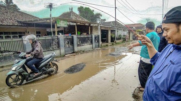 Warga melaksanakan aksi mancing bersama di jalan rusak sebagai aksi protes kepada Pemkab Bandung Barat, Senin (27/2/2023).