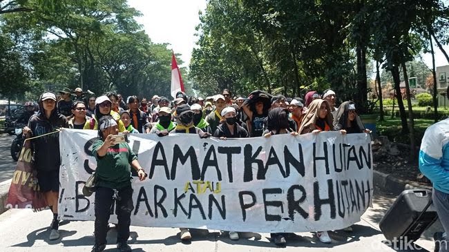 Demonstran di Kantor Perhutani Jabar membentangkan spanduk soal kerusakan alam di Ranca Upas (foto - Sudirman Wamad/detikJabar)