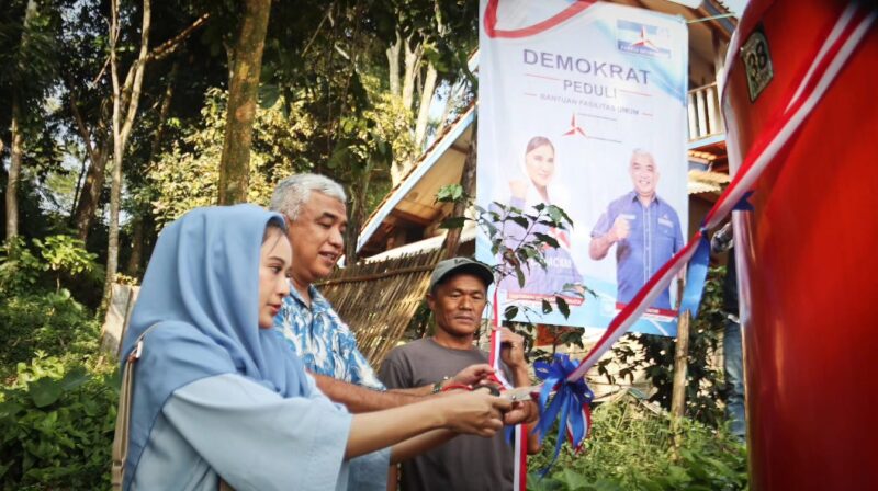 Ketua DPC Demokrat Kabupaten Bandung Saeful Bachri, SH., M.A.P didampingi Tantriani Dewi Martadinata melakukan gunting pita saat acara peresmian dan penyerahan Bak Penampungan air serta pembangunan toilet umum bagi warga di Desa Campaka Mulya Kecamatan Cimaung Kabupaten Bandung. Minggu 28 Mei 2023.