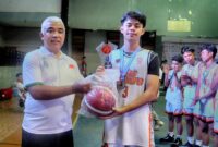 Kapten tim patriot beezers menerima trophy dan bola juara ke-1 dari Ketua Perbasi Kabupaten Bandung Saeful Bachri, SH., M.AP setelah mengalahkan tim New Cosmo di laga final turnamen basket Perbasi Cup 2023 di Gor Koni Majalaya. Kamis (19/10) 