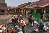 Pramuka Peduli Kwarcab Kabupaten Bandung berjibaku bersama relawan lain memebersihkan lumpur di SDN 01 Baturengat dan permukiman di Kampung Blok Hawu, Desa Cigondewah Hilir, Kecamatan Margaasih, akibat terendam banjir, Rabu (6/12/2023).