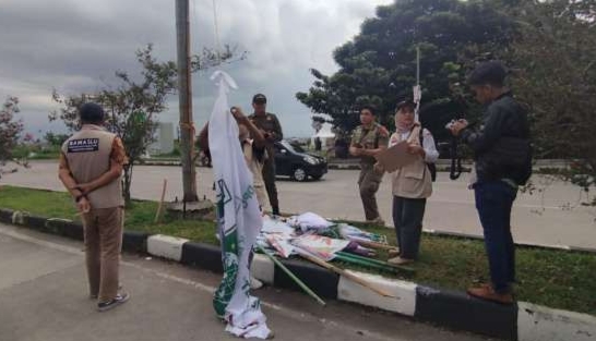 Petugas Bawaslu saat menertibkan APK yang dipasang melanggar melanggar aturan.(foto Didi M RRI)